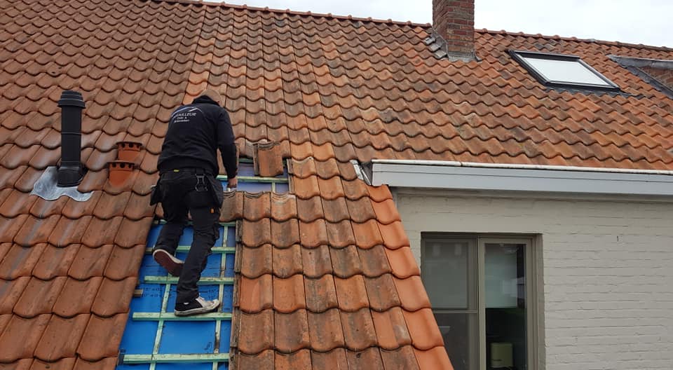 De dakdekker legt dakpannen na een dakrenovatie